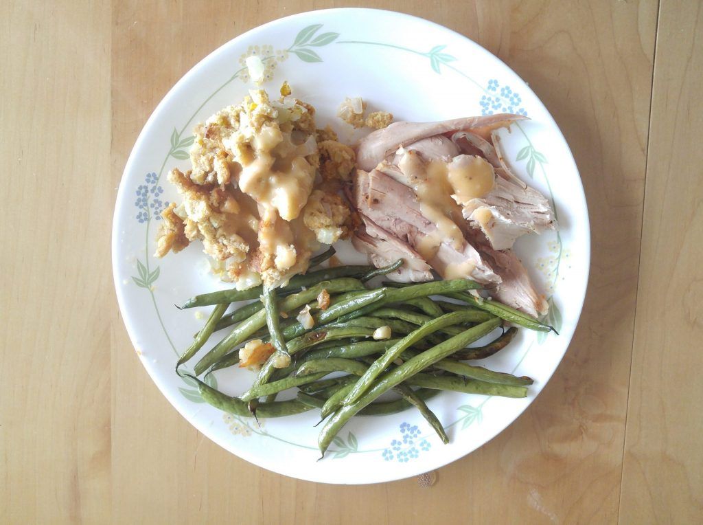 Turkey with brown gravey; stuffing; roasted garlic green beans.