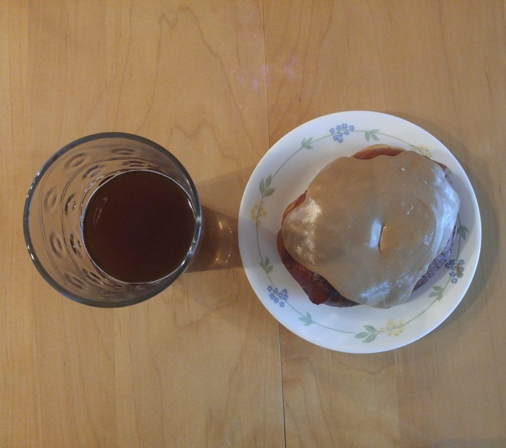 Homemade donut with maple glaze and coffee.